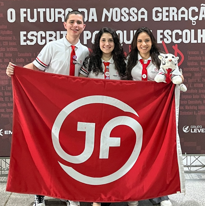 Membros da Júnior FEA-RP com a bandeira da empresa