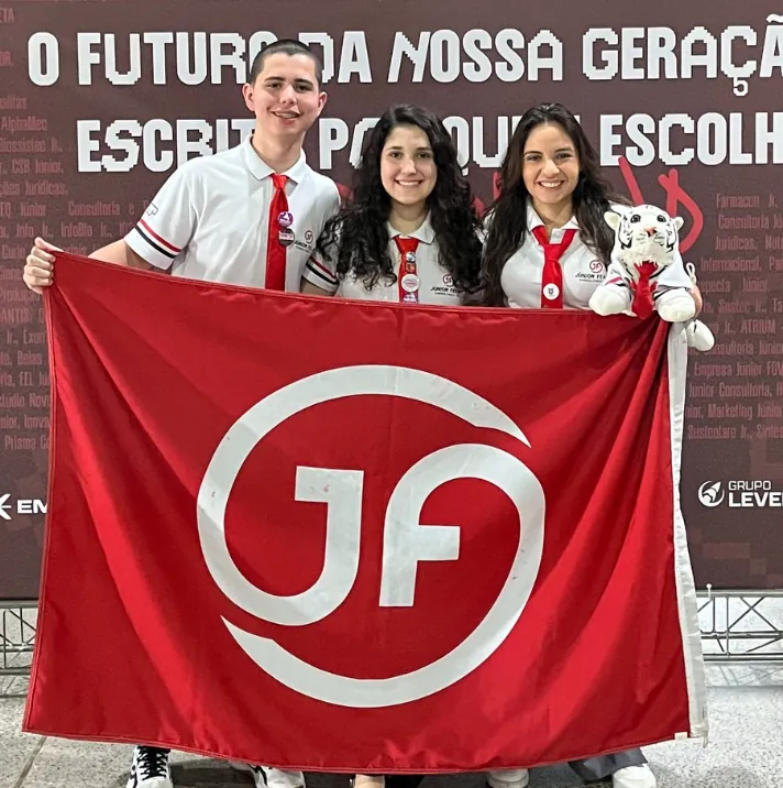 Membros da Júnior FEA-RP com a bandeira da empresa